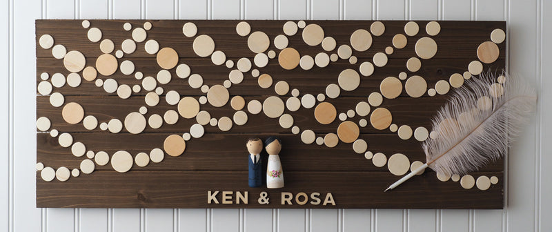 Personalized Wedding Guest book with hand-painted bride and groom peg dolls.   Have your guests sign a wooden circle, depicting lantern lights.  Hang this guestbook after the wedding to preserve beautiful memories of your special day for many years to come.  This 28"x11" wooden Wedding guest book alternative consist of up to 110 sign-able wooden circles.  It is sufficient for at least 150 guests.