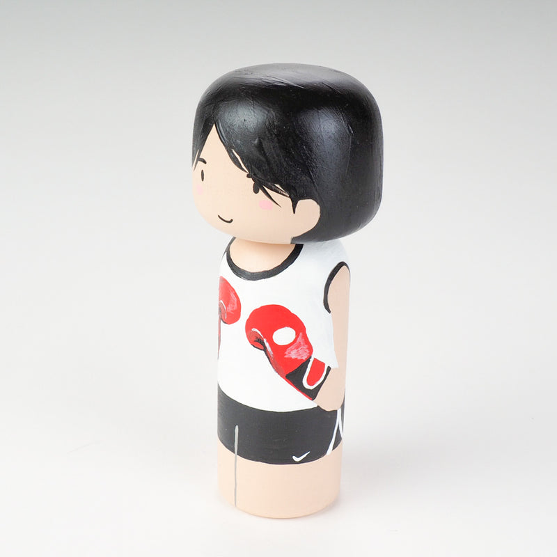 Kicking boxing Kokeshi doll. Introducing our new family portrait Kokeshi dolls!  Give something unique and personalized.  Customize your family, friends, or colleagues on Kokeshi dolls!  They are hand-painted with love that show the uniqueness of each individual such as specific sports or hobby.  Here is a family member who loves kickboxing but we can customize any sports or hobby.
