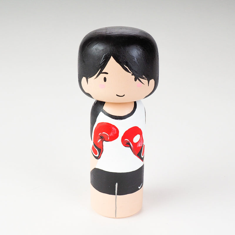 Kicking boxing Kokeshi doll. Introducing our new family portrait Kokeshi dolls!  Give something unique and personalized.  Customize your family, friends, or colleagues on Kokeshi dolls!  They are hand-painted with love that show the uniqueness of each individual such as specific sports or hobby.  Here is a family member who loves kickboxing but we can customize any sports or hobby.